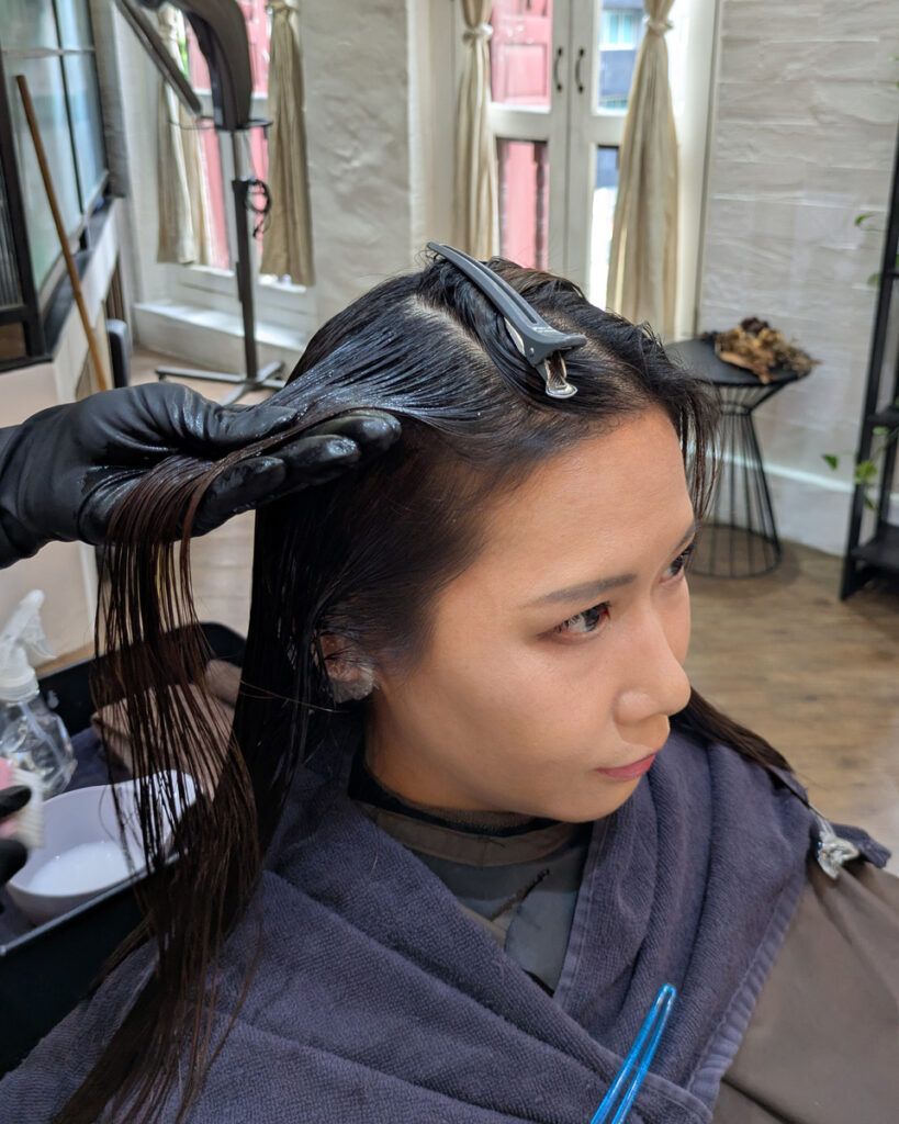 Kaizenケラチントリートメントの薬剤を丁寧に塗布し、25分間自然放置している場面。髪に栄養を浸透させている最中。