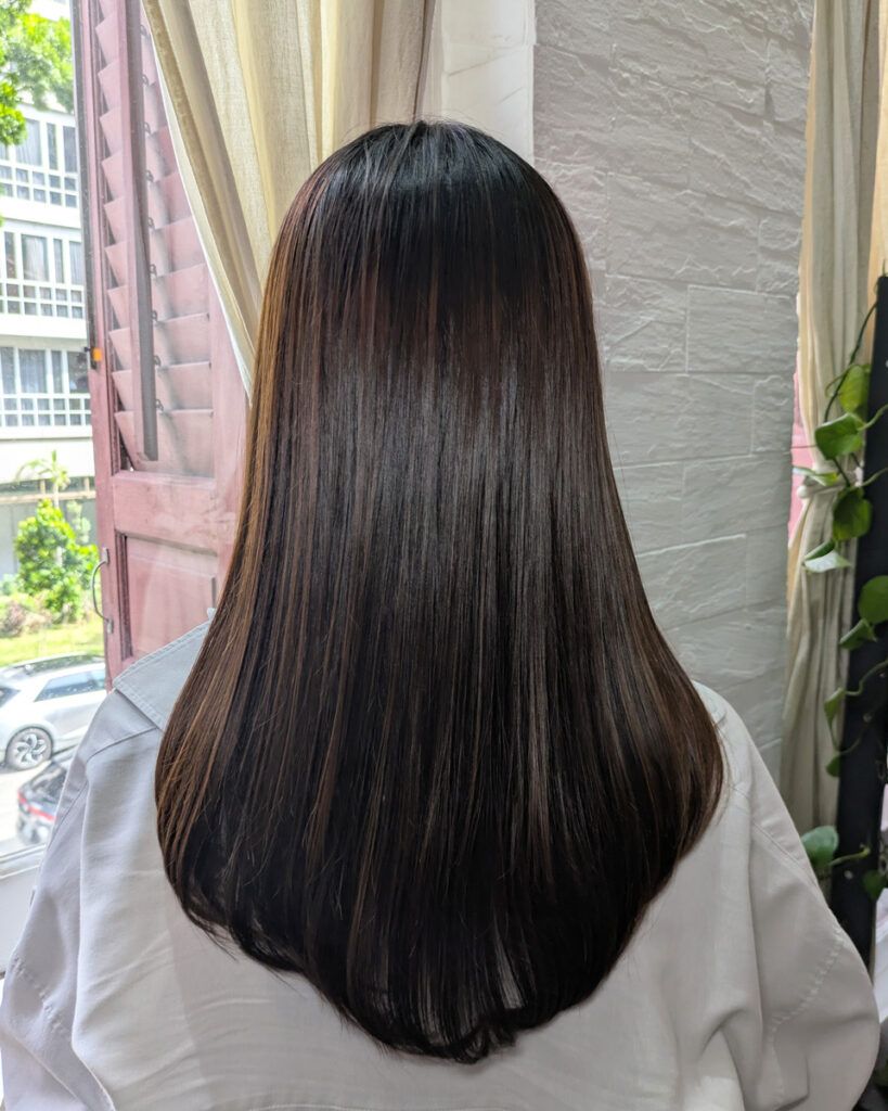 施術後、ツヤとまとまりを取り戻した髪。自然光の下で輝くつやつやの髪が印象的。