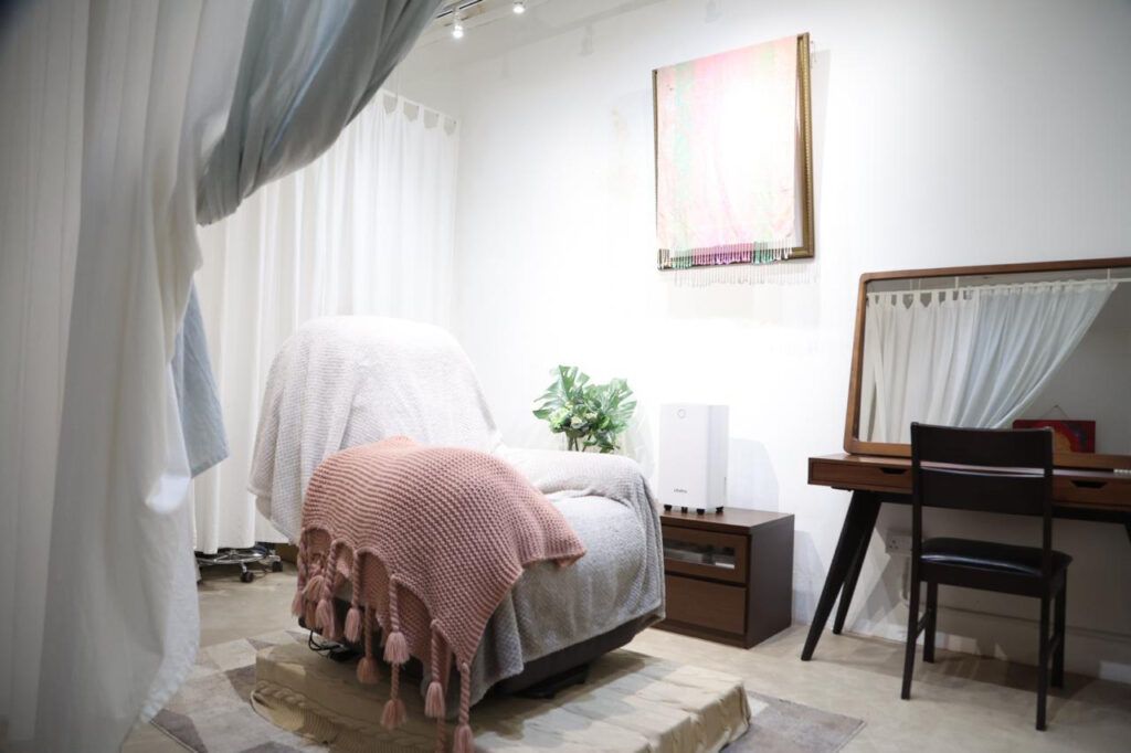 白いカーテンで仕切られた、明るくナチュラルな雰囲気の施術ルーム