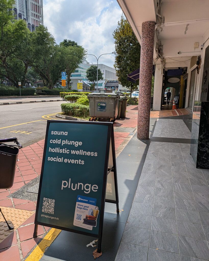 シンガポールのPlunge店舗前看板。サウナ、コールドプランジ、ホリスティックウェルネスを案内